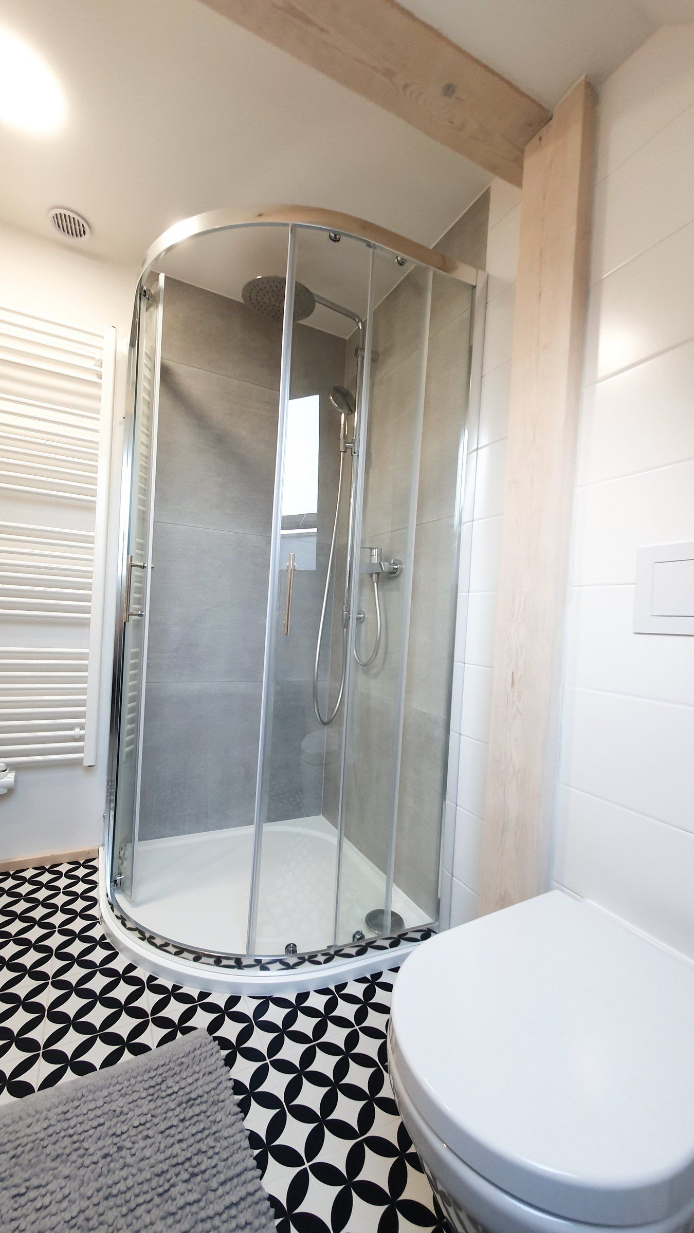 Koupelna apartmánu III: sprchový kout a záchod, černobílá dlažba