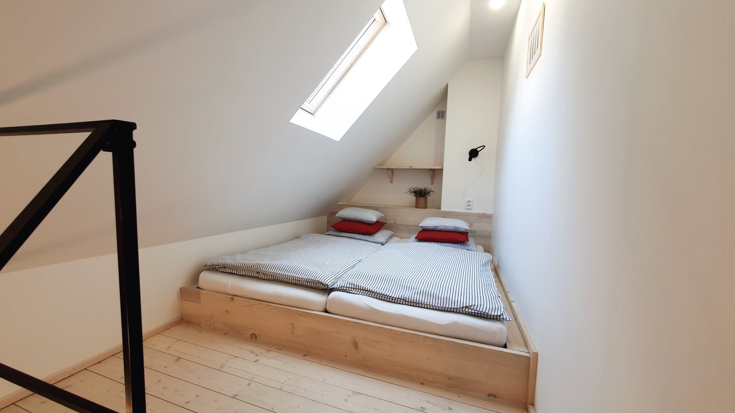 Galerie apartmánu IV s manželskou postelí a střešním oknem