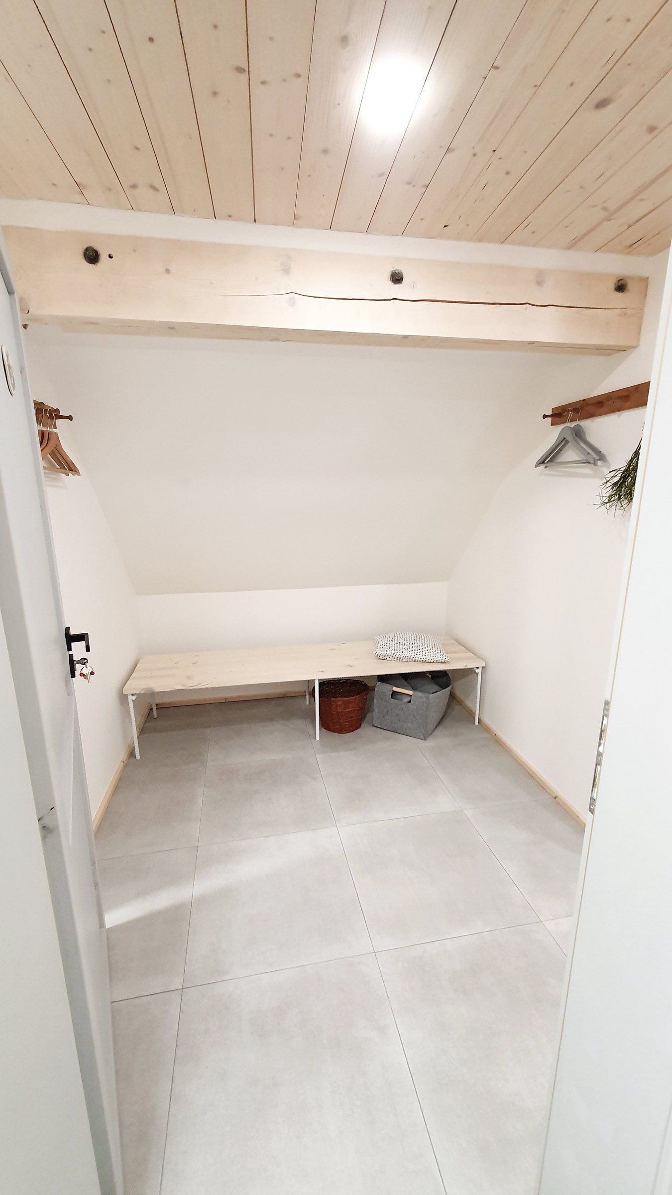 Vstupní chodba apartmánu IV: lavice pod šikminou a věšák na zdi